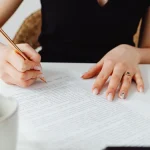 Person proofreading a printed page at a desk